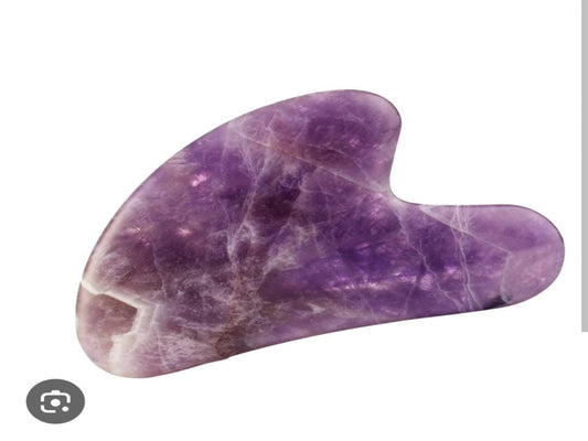Amethyst gua sha facial massage tool in purple polished stone.
